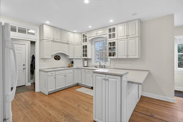 a kitchen with white cabinets and white appliances