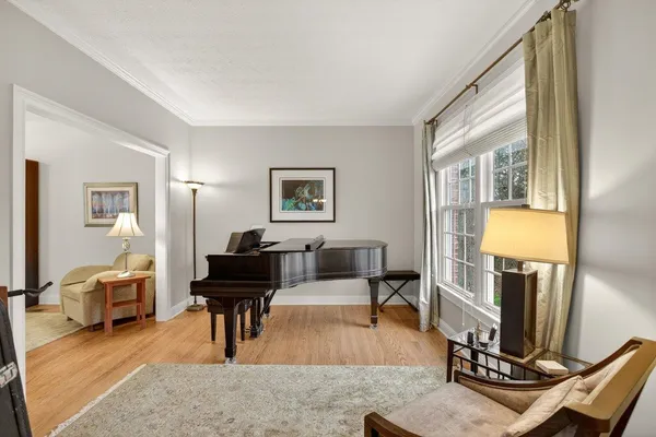 a living room with furniture piano and a window