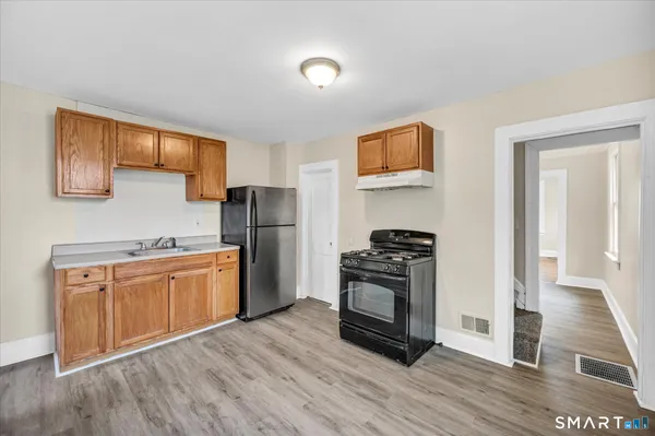 a kitchen with granite countertop wooden floors and stainless steel appliances