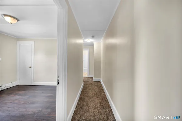 a view of a hallway with wooden floor