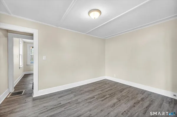 a view of an empty room with wooden floor