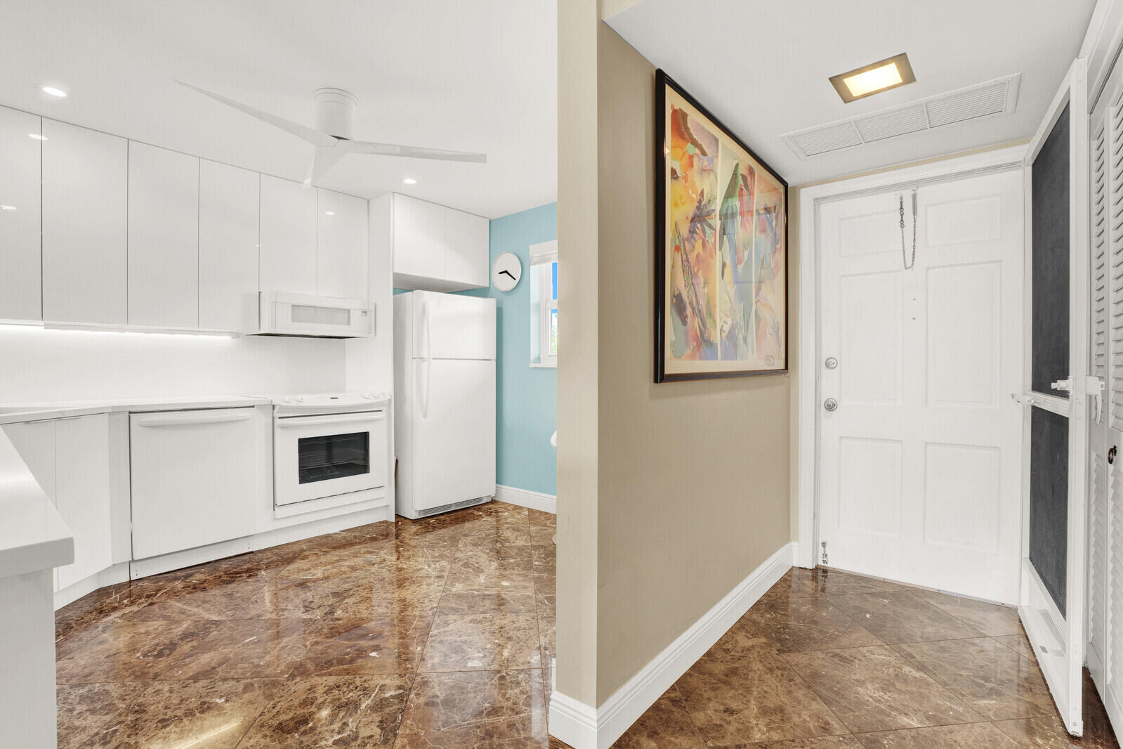 80 Celestial Way, Unit 109 Juno Beach, FL 33408 - Photo 2 of 40 a view of a kitchen with white cabinets and wooden floor