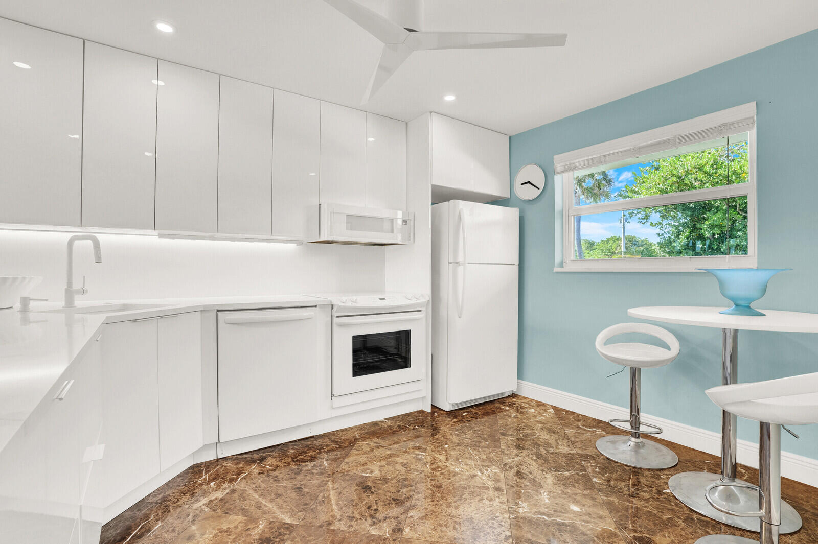 80 Celestial Way, Unit 109 Juno Beach, FL 33408 - Photo 3 of 40 a kitchen with stainless steel appliances granite countertop a refrigerator sink and white cabinets