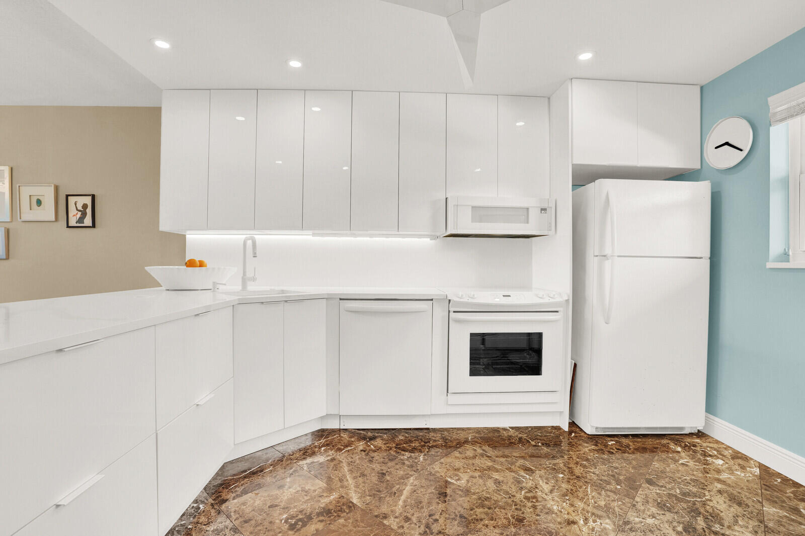80 Celestial Way, Unit 109 Juno Beach, FL 33408 - Photo 4 of 40 a kitchen with a refrigerator a stove top oven and white cabinets