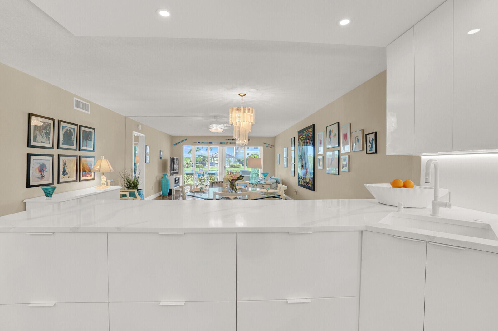 80 Celestial Way, Unit 109 Juno Beach, FL 33408 - Photo 8 of 40 a kitchen with kitchen island a stove a sink a dining table and chairs