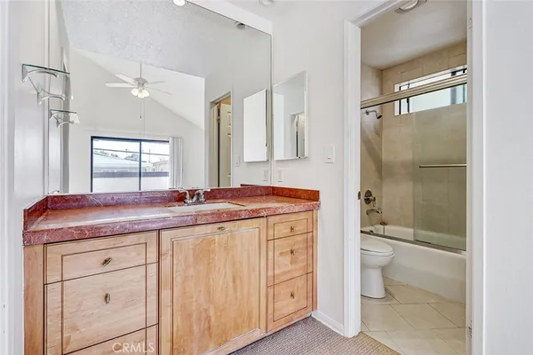 a bathroom with a granite countertop sink a toilet and a shower