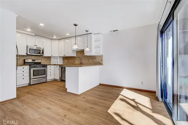 a kitchen with stainless steel appliances granite countertop a refrigerator a stove top oven a sink and dishwasher