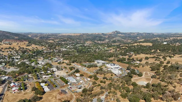 an aerial view of residential house with yard and mountain view in back