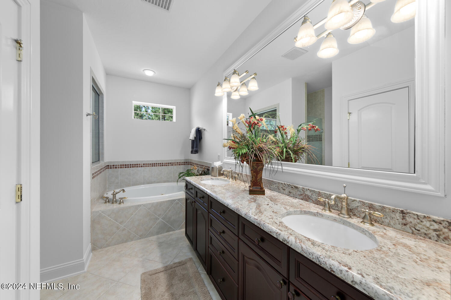752 Promenade Pointe Drive St. Augustine, FL 32095 - Photo 61 of 117 a bathroom with a granite countertop double vanity sink a large mirror and a bathtub