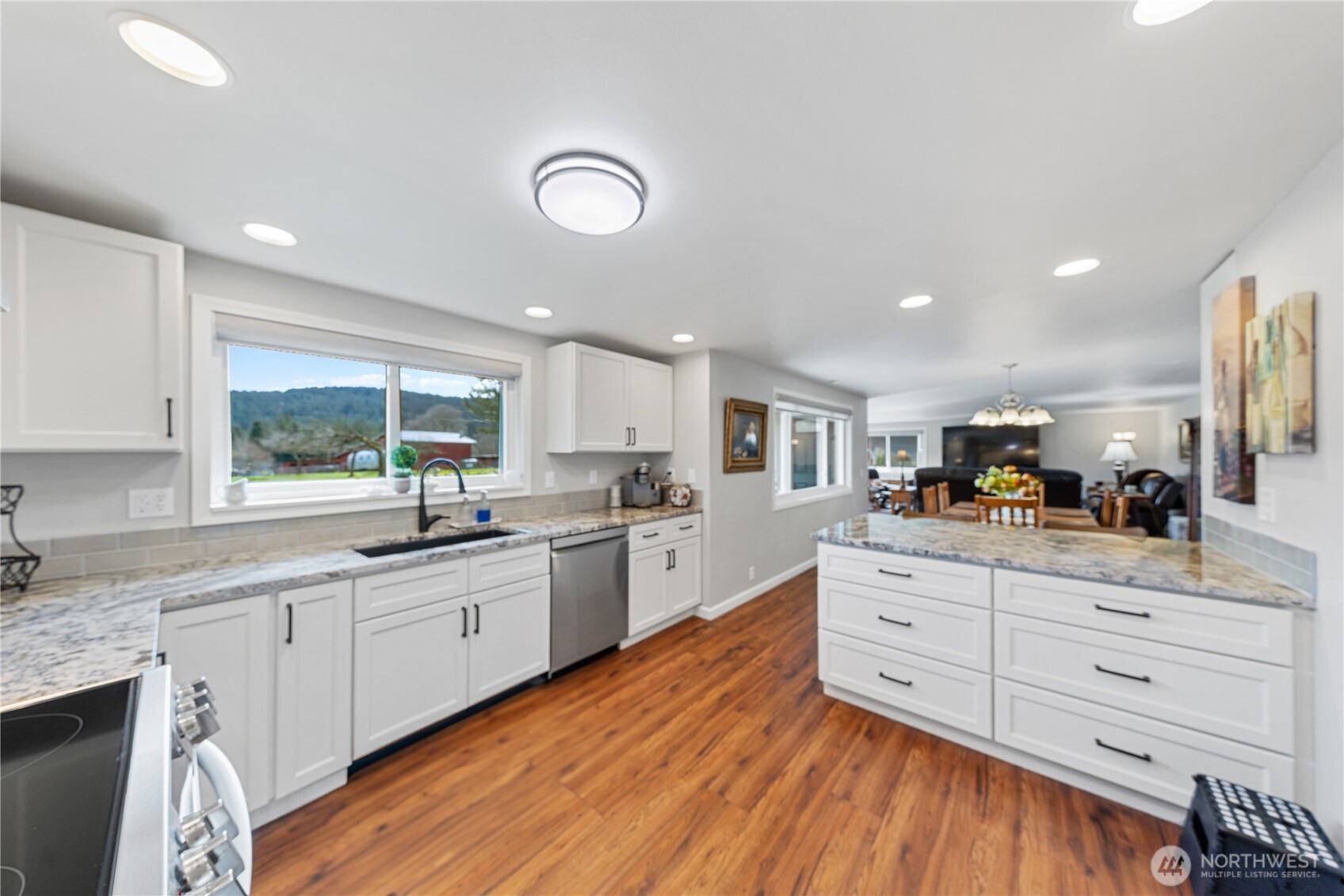 802 Haddon Road Anacortes, WA 98221 - Photo 13 of 36 a kitchen with granite countertop white cabinets and white appliances