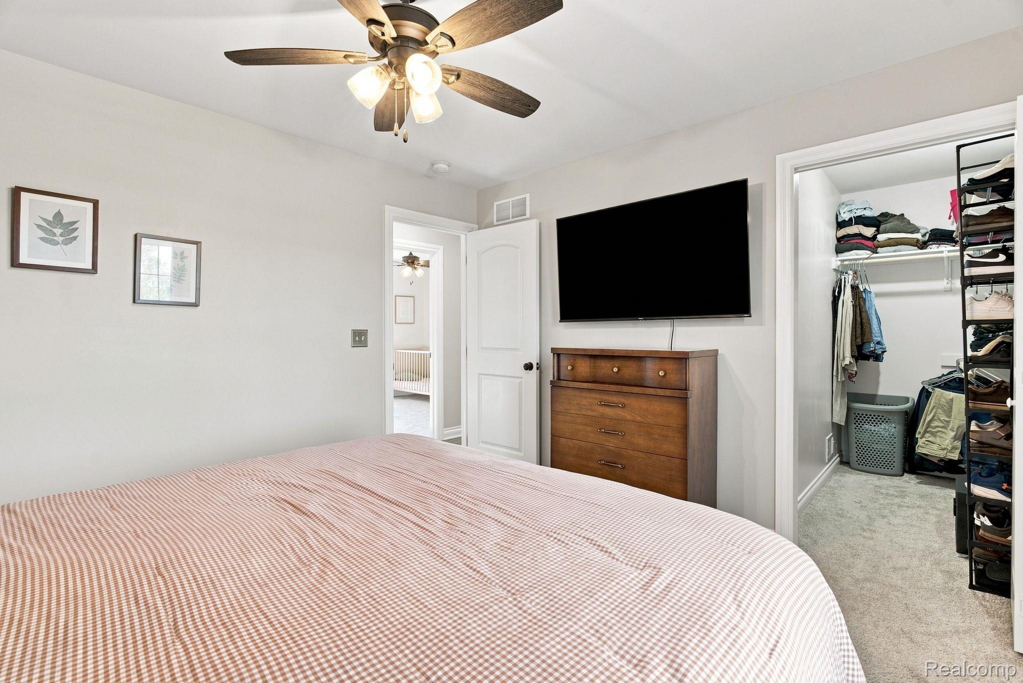 629 Range Road Smiths Creek, MI 48074 - Photo 21 of 36 Ceiling fan with integrated lighting, wall-mounted television, and a built-in closet with shelving and hanging rods