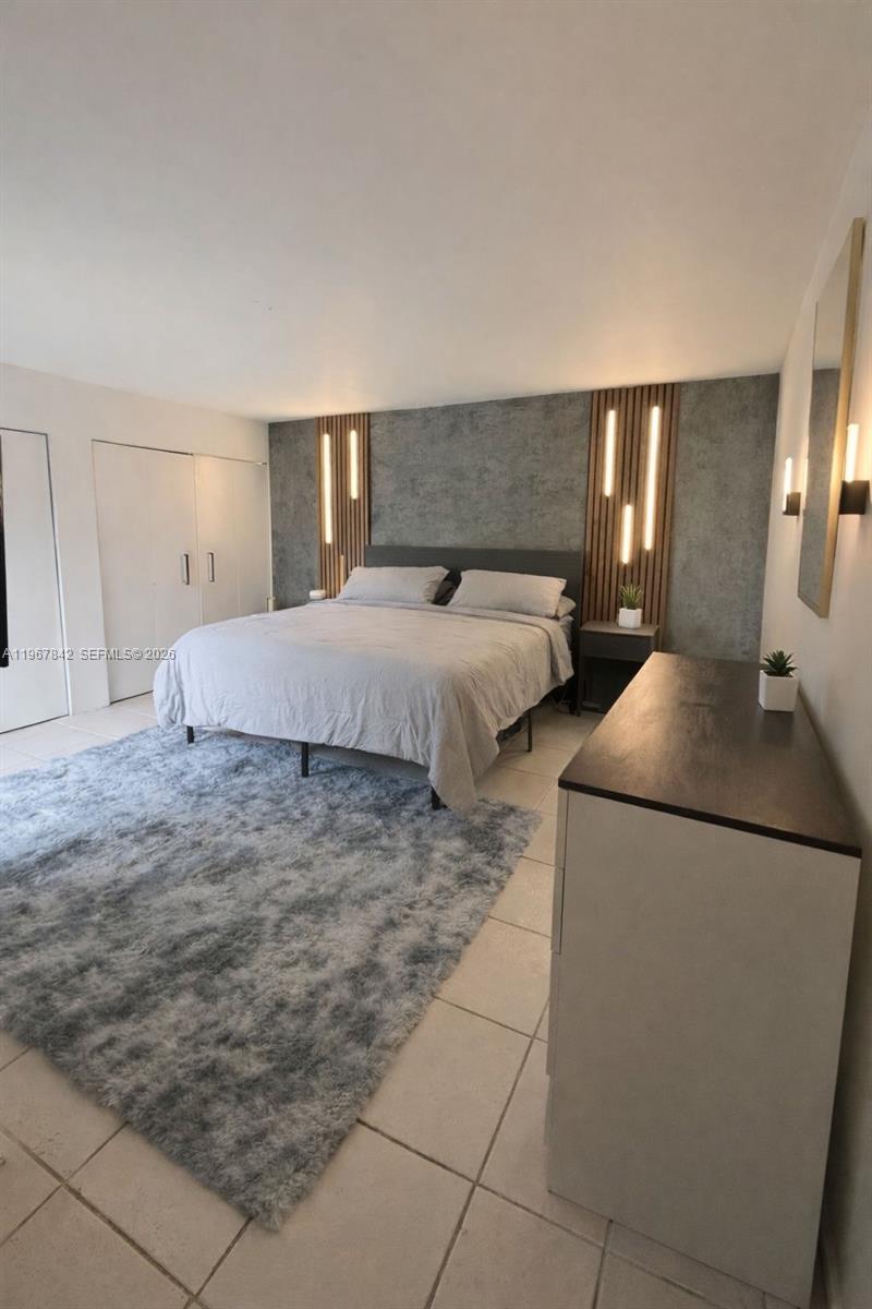 283 Woodland Road, Unit 283 Palm Springs, FL 33461 - Photo 13 of 28 a spacious bedroom with a bed and a cabinets