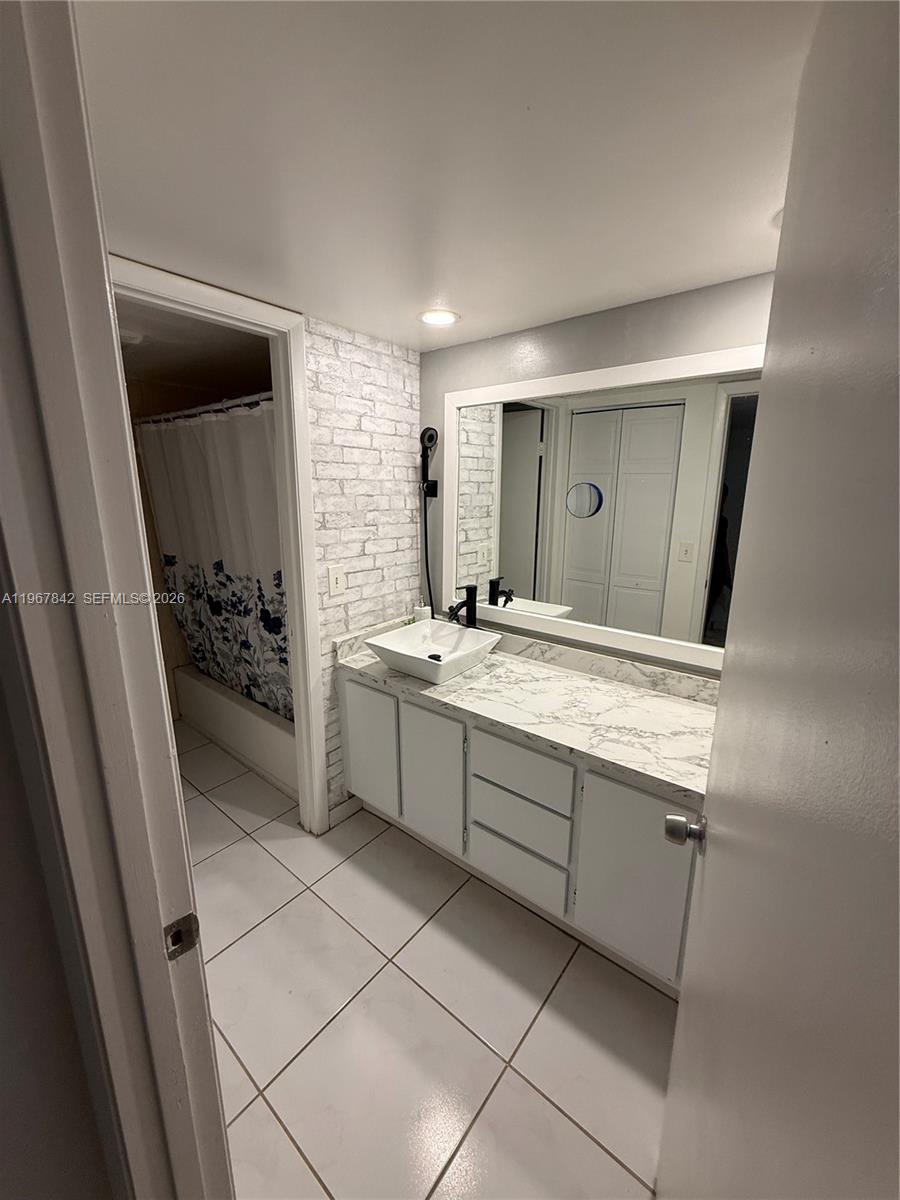 283 Woodland Road, Unit 283 Palm Springs, FL 33461 - Photo 18 of 28 a bathroom with a sink a mirror and a shower