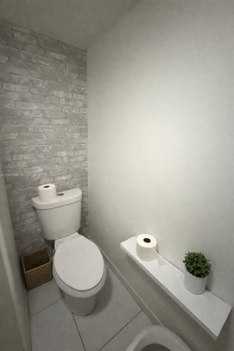 283 Woodland Road, Unit 283 Palm Springs, FL 33461 - Photo 19 of 28 a white toilet sitting next to a white sink