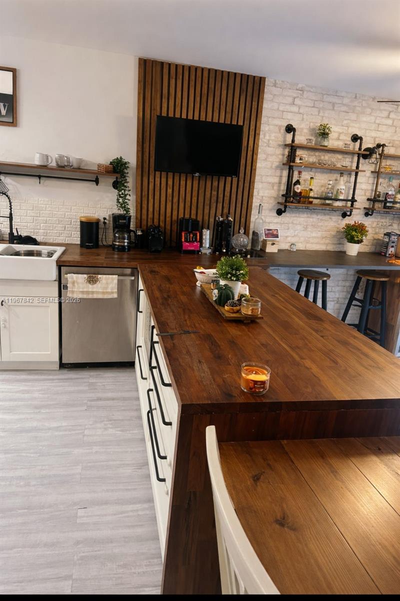 283 Woodland Road, Unit 283 Palm Springs, FL 33461 - Photo 2 of 28 a kitchen with a table chairs and a stove