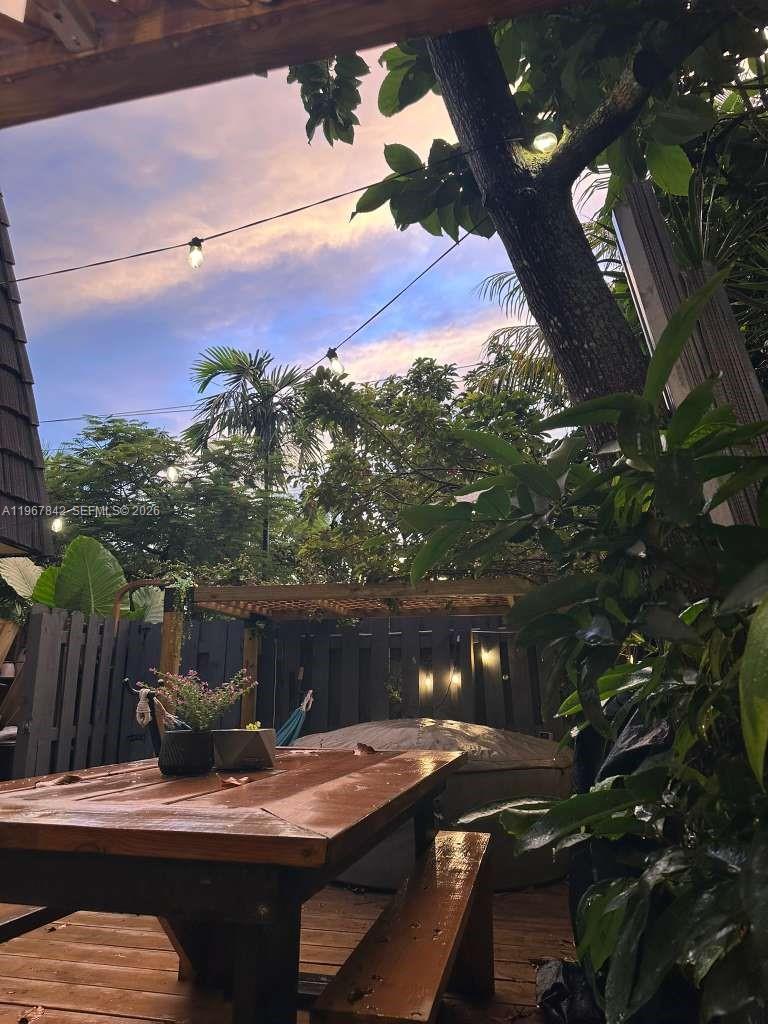 283 Woodland Road, Unit 283 Palm Springs, FL 33461 - Photo 23 of 28 a view of a patio with table and chairs and a fire pit