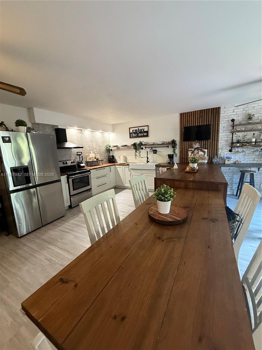 283 Woodland Road, Unit 283 Palm Springs, FL 33461 - Photo 3 of 28 a kitchen with sink refrigerator and stove