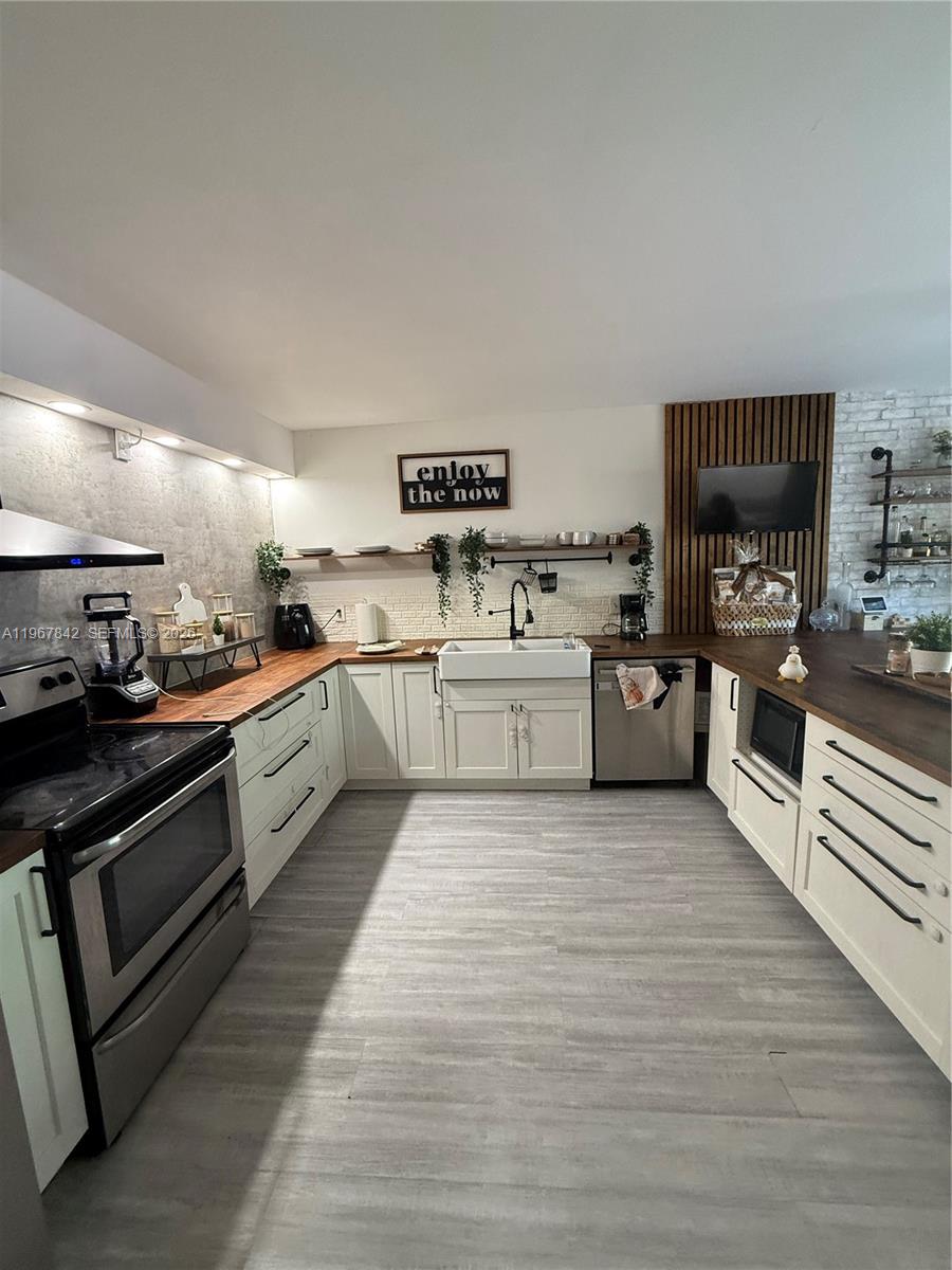 283 Woodland Road, Unit 283 Palm Springs, FL 33461 - Photo 7 of 28 a large kitchen with a stove top oven and cabinets