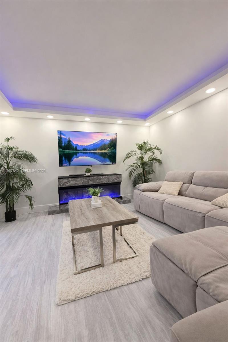 283 Woodland Road, Unit 283 Palm Springs, FL 33461 - Photo 8 of 28 a living room with furniture and a flat screen tv