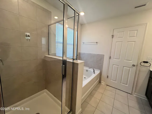 an empty room with chandelier fan and windows
