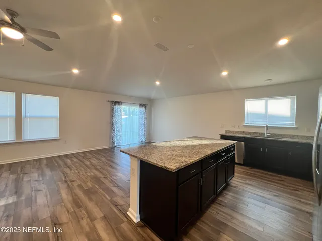 a view of kitchen view wooden floor and stainless steel appliances