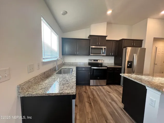 a kitchen with a stove and wooden floor