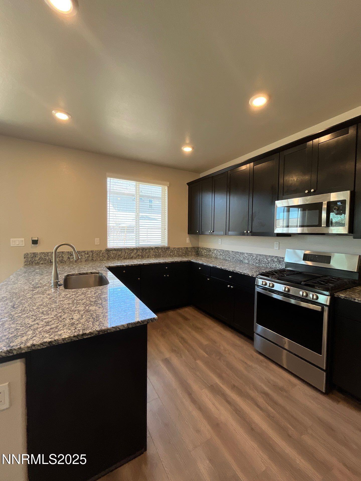 1982 Maradona Drive Sparks, NV 89436 - Photo 2 of 20 a kitchen with stainless steel appliances granite countertop a sink a stove a microwave and island