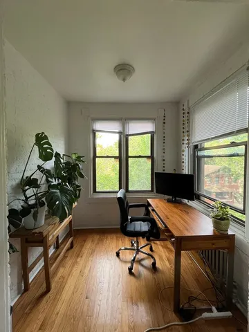 a room with wooden floor pool table and windows