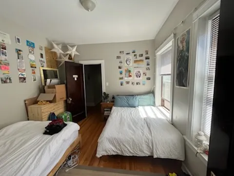 a bedroom with a bed and wooden floor