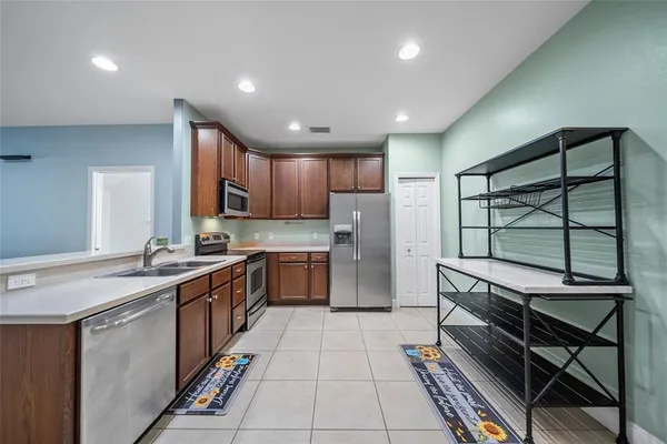 a kitchen with stainless steel appliances granite countertop a sink counter space cabinets and a large window