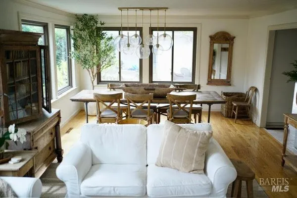 a living room with furniture large window and wooden floor