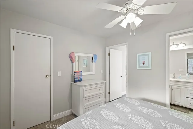 a bedroom with a bed and a lamp on the dresser