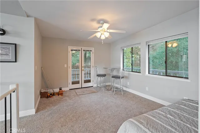 a view of a house with large windows and flower plants