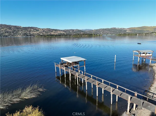 a kitchen with stainless steel appliances granite countertop a refrigerator a stove and a sink with wooden cabinets