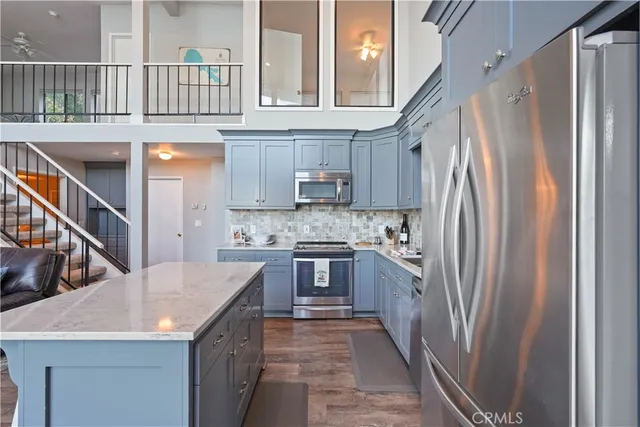 a kitchen with stainless steel appliances granite countertop a kitchen island a stove a cabinets a sink and a refrigerator