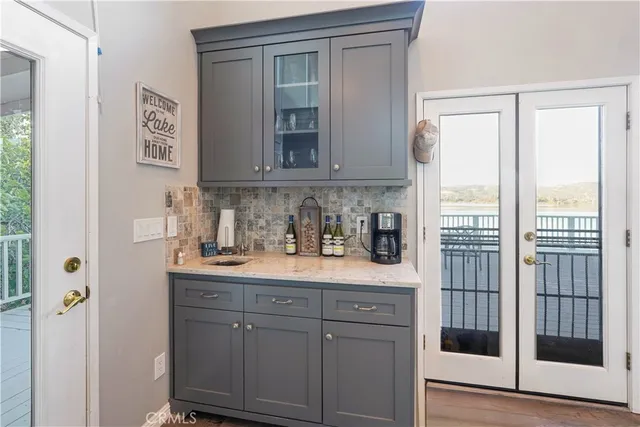 a kitchen with stainless steel appliances granite countertop a refrigerator a sink dishwasher a stove a dining table and chairs with wooden floor