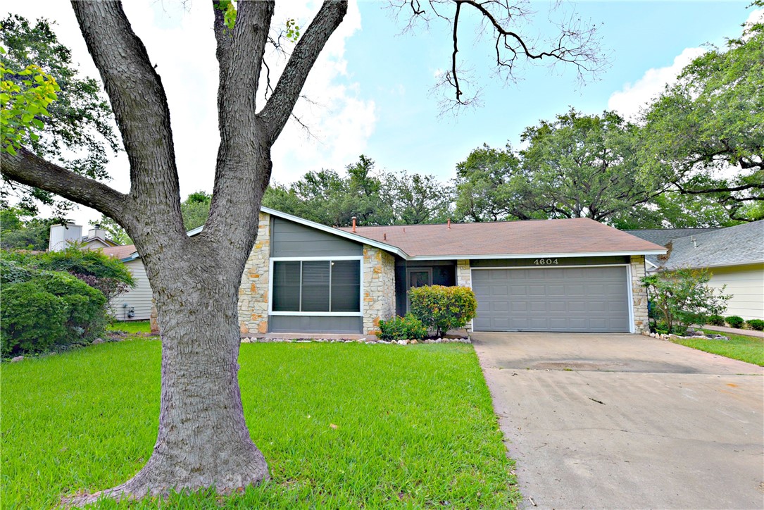 a front view of a house with a garden and trees