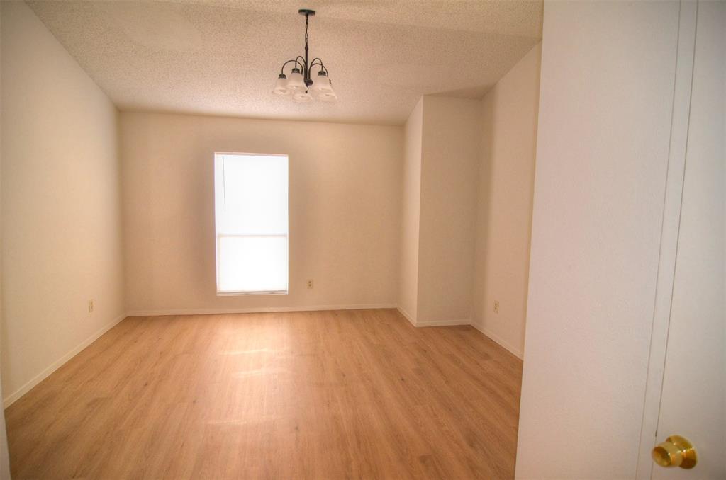 10500 Lake June Road, Unit B07 Dallas, TX 75217 - Photo 6 of 6 a view of an empty room with wooden floor and a window