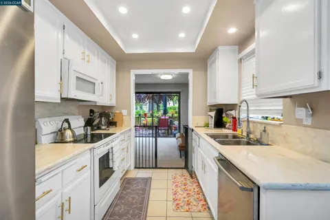 a kitchen with white cabinets and stainless steel appliances