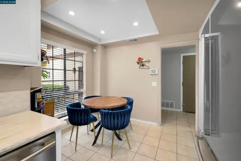 a kitchen with stainless steel appliances kitchen island a table and chair