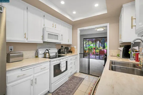 a large white kitchen with stainless steel appliances granite countertop lots of counter top space
