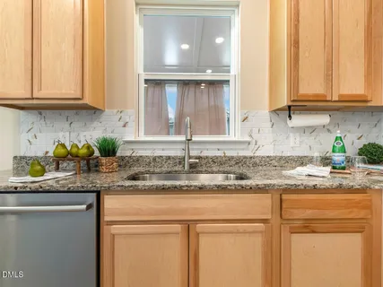 a kitchen with granite countertop stainless steel appliances a stove a sink and cabinets