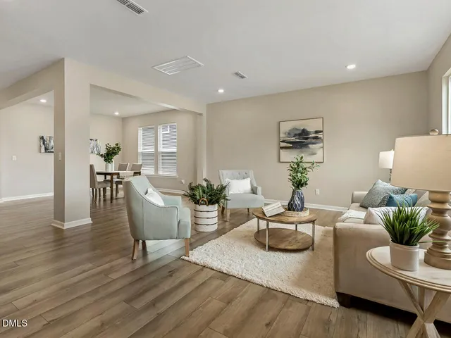 a living room with furniture wooden floor and a large window