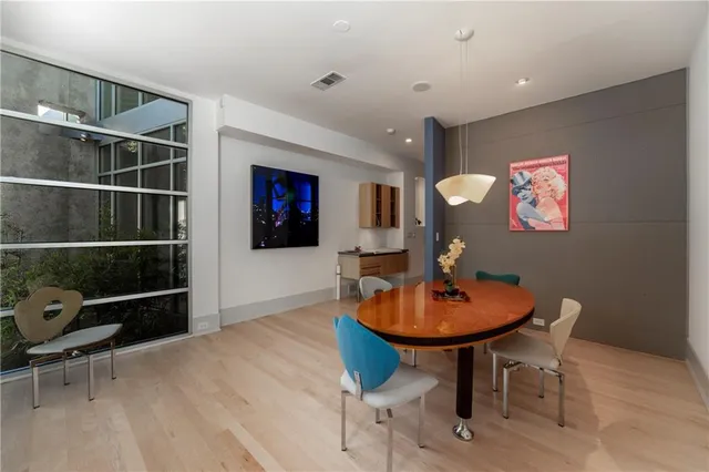 a dining room with furniture wooden floor and a floor to ceiling window