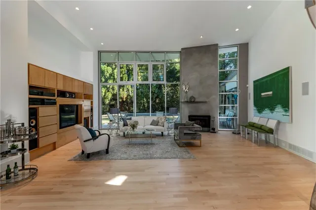 a living room with furniture large window and flat screen tv