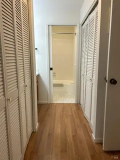 a view of a hallway with wooden floor and staircase