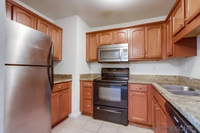 a kitchen with granite countertop cabinets stainless steel appliances and a sink