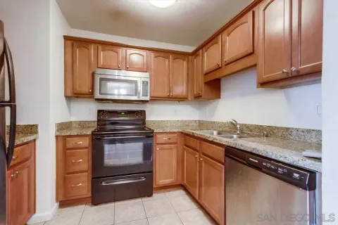 a kitchen with granite countertop wooden cabinets and a stove top oven