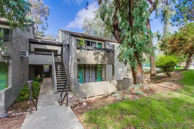 a view of a house with a yard and potted plants