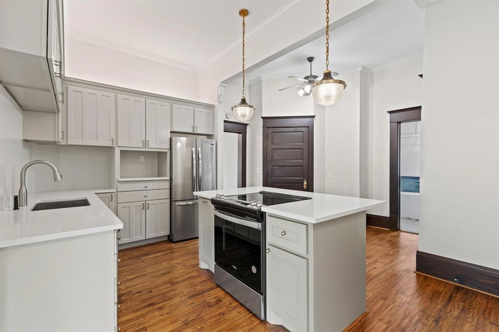 1001 West Morton Street Denison, TX 75020 - Photo 19 of 37 a kitchen with a stove sink and refrigerator